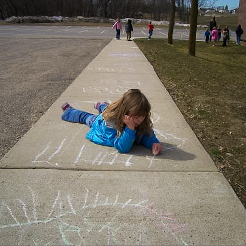 Child Drawing with chalk on sidewalk