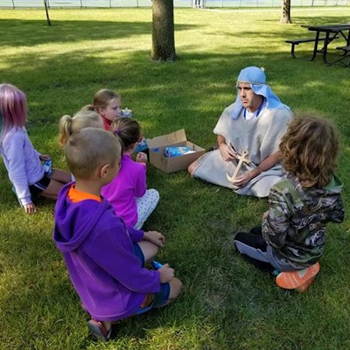 Man teaching a bible story to children